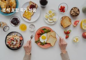 a table full of breakfast food with a person holding a fork at No 25 Iksan Station Branch in Iksan