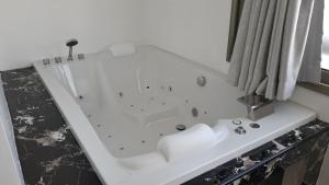 a white bath tub sitting next to a window at PATONG TOWER Residence Apartments 2026 in Patong Beach