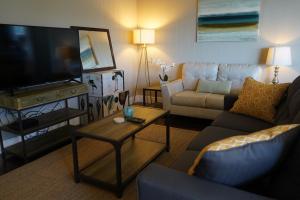 a living room with a couch and a flat screen tv at East Side Beach House in Santa Cruz