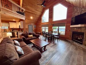 a living room with a couch and a table at Riverfront Blue Jay Cabin in Murphy