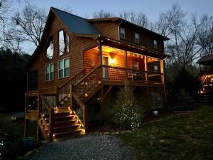 a large wooden house with a christmas tree in front of it at Riverfront Blue Jay Cabin in Murphy