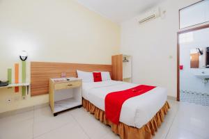 a bedroom with a large bed and a bathroom at RedDoorz Plus at Amalio Hotel Surapati in Bandung