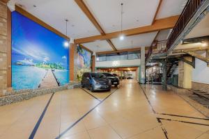 a large mural in a building with cars parked at RedDoorz Plus at Amalio Hotel Surapati in Bandung