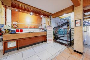 a restaurant with a counter and stairs in a room at RedDoorz Plus at Amalio Hotel Surapati in Bandung