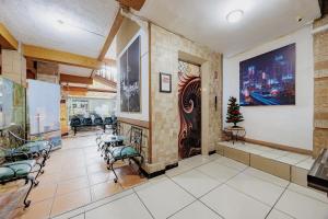a waiting room with chairs and a large painting on the wall at RedDoorz Plus at Amalio Hotel Surapati in Bandung