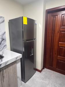 a stainless steel refrigerator in a kitchen next to a door at Suite ejecutiva con Parqueo Privado in Latacunga