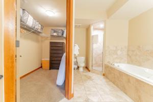 a bathroom with a tub and a toilet and a sink at Cascade Penthouse by Canadian Rockies Vacation Rentals in Canmore +37 photos