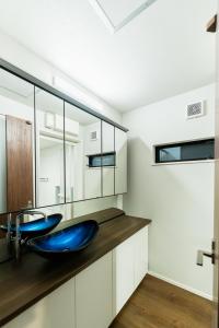 a bathroom with a blue sink and a mirror at Flower Base Botan in Fukuoka