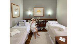 a woman sitting in a hospital room with two beds at SPA LIFESTYLE Centro de Bem Estar in Canela +82 photos