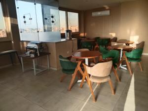 a restaurant with tables and green chairs in a room at The Nomad Pyramids Boutique Hotel in Cairo