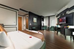 a hotel room with a large bed and a desk at HALO HANOI HOTEL in Hanoi