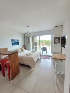 a bedroom with a bed and a table and a dining room at VIENTOS apartments in Villa Gesell
