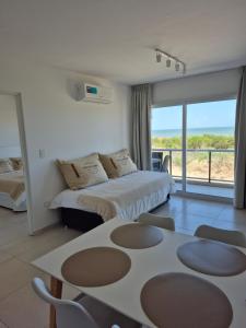 a hotel room with a bed and a table and chairs at VIENTOS apartments in Villa Gesell +56 photos