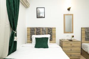 a bedroom with a white bed and a green curtain at Museum Land Boutique Hotel in Cairo