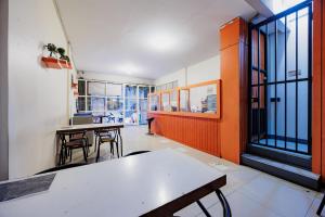 a room with tables and chairs and windows at Hotel C18 at Cibaduyut Mitra RedDoorz in Bandung