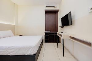 a hotel room with a bed and a television at Hotel C18 at Cibaduyut Mitra RedDoorz in Bandung
