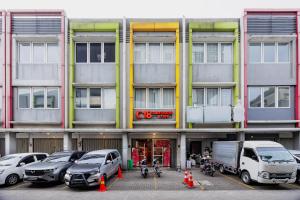 a parking lot with cars parked in front of a building at Hotel C18 at Cibaduyut Mitra RedDoorz in Bandung