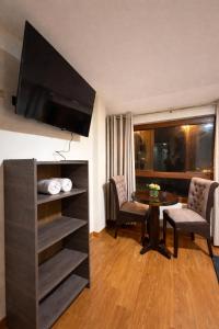 a living room with a table and a tv in a room at Hospedaje chakana inn in Cusco