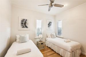 two beds in a room with white walls and windows at Ocean Blue - Gnarabup NEW in Gnarabup