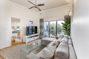 a living room with a couch and a tv at Ocean Blue - Gnarabup NEW in Gnarabup