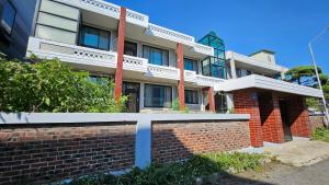 a building with a brick fence in front of it at Tov Stay Atti in Pyeongtaek