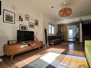 a living room with a television and a couch at Chao phraya riverfront house Baan Rimphraya in Bangkok
