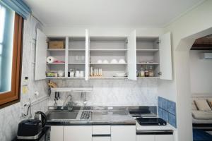 a kitchen with white cabinets and a sink at Tov Stay Atti in Pyeongtaek
