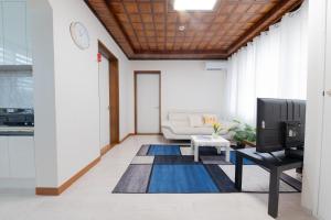 a living room with a couch and a tv at Tov Stay Atti in Pyeongtaek