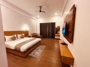 a bedroom with a bed and a flat screen tv at Serene Forest Resort in Nainital