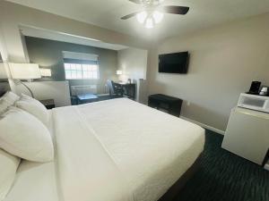 a hotel room with a white bed and a television at BridgePointe Inn & Suites by BPhotels, Lincoln I-80 & 27th St in Lincoln +9 photos