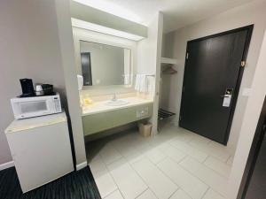 a bathroom with a sink and a microwave at BridgePointe Inn & Suites by BPhotels, Lincoln I-80 & 27th St in Lincoln