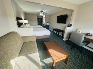 a hotel room with a bed and a couch and a desk at BridgePointe Inn & Suites by BPhotels, Lincoln I-80 & 27th St in Lincoln