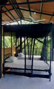 a bedroom with a canopy bed in a room at Wildcat hostel Yala in Kataragama