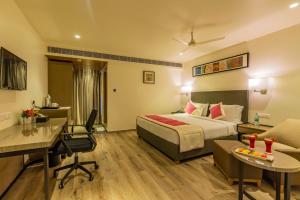a hotel room with a bed and a desk at Quality Inn Ramachandra in Visakhapatnam