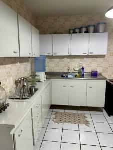 a kitchen with white cabinets and a counter top at Caruaru house in Caruaru +13 photos