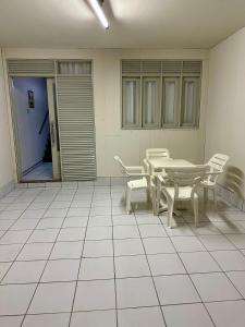 a room with a table and chairs on a tiled floor at Caruaru house in Caruaru