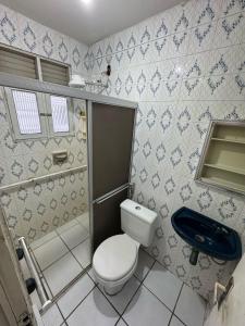 a bathroom with a toilet and a sink at Caruaru house in Caruaru
