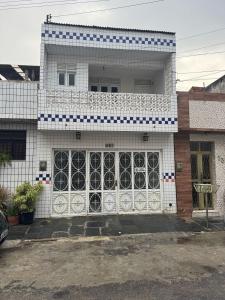 a white and blue building with a large door at Caruaru house in Caruaru