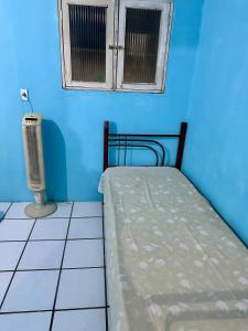 a blue room with a bed and a window at Caruaru house in Caruaru