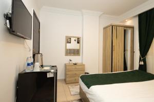a hotel room with a bed and a television at Museum Land Boutique Hotel in Cairo