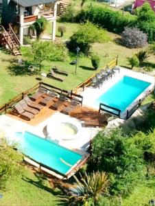 an overhead view of a swimming pool with chairs and a swimming pool at Cabañas el Recodo de Potrero in Potrero de Garay