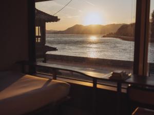 ein Zimmer mit Fenster und Blick aufs Wasser in der Unterkunft SOIL Setoda in Onomichi