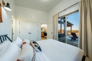 a bedroom with a white bed and a balcony at Brycegate Retreat. Stunning Views. Modern Comforts. in Hatch +43 photos