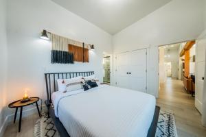 a white bedroom with a large bed and a table at Brycegate Retreat. Stunning Views. Modern Comforts. in Hatch