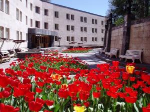 un jardín de flores rojas y amarillas frente a un edificio en Дом Писателей Цахкадзора, en Tsaghkadzor