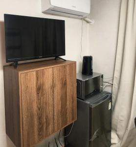 a flat screen tv on top of a wooden entertainment center at 낙원파크포도홈 in P'ungnyŏn-gol
