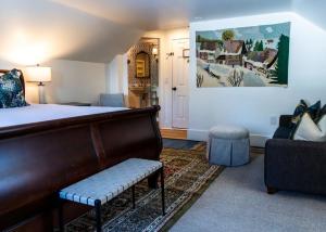 a bedroom with a bed and a couch and a chair at Inn at Pleasant Lake in New London