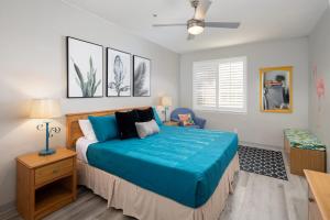 a bedroom with a bed with a blue blanket at Seaside Flamingo Retreat in Oceano +8 photos