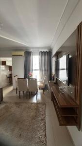 a living room with a table and a dining room at Brisas do Lago 2 Quartos in Palmas