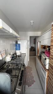 a kitchen with a stove and a counter top at Brisas do Lago 2 Quartos in Palmas +16 photos